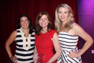 Three women smile at the camera