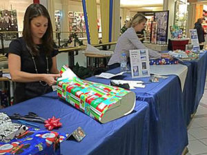 JLB Community volunteer wrapping a holiday gift 