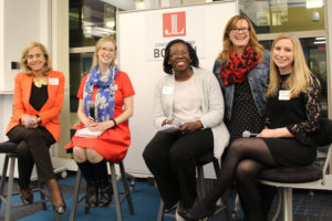 Four smiling women are seated together as panelists. From left to right, the women are: Ginny Harris, Pamela Lynch, Zara Spooner, moderator Tracy Prabhu, and Hayley Hannan